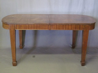 An Edwardian oval mahogany extending dining table with 1 extra  leaf