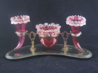 A Victorian cranberry glass desk set comprising circular bowl,  chipped, 2 cornucopia shaped vases 1 chipped, raised on a gilt  metal and mirrored base 10"