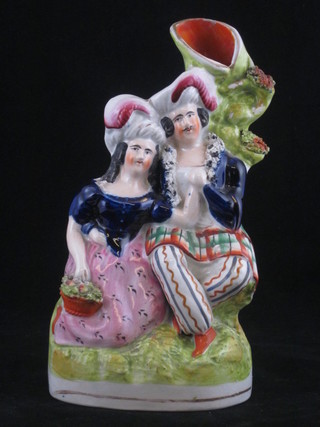 A 19th Century Staffordshire spill vase in the form of a seated lady and gentleman, 8", slight chip