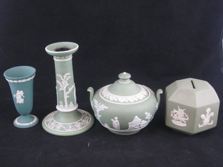 A Wedgwood sage green jasperware octagonal money box to commemorate the Investiture of Prince Charles, do. candlestick,  jar and cover and a vase