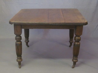 An Edwardian mahogany extending dining table with 1 extra  leaf, raised on turned and reeded supports