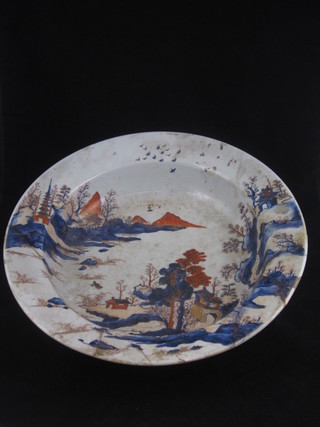 A circular Japanese Imari porcelain bowl decorated trees and mountains, 14", f and r,