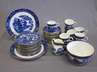 A 37 piece Coalport blue glazed tea service comprising 6" sugar bowl, cracked, cream jug 4", 2 10" bread plates, 12 7" tea  plates - 9 cracked, 12 cups and 12 saucers - 8 cups and 10  saucers cracked, decorated the Willow pattern