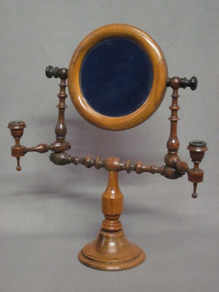 A Victorian bevelled plate mirrored shaving stand contained in a walnut frame with candle sconces, raised on a circular spreading  base