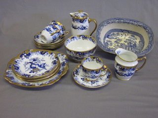 An 18 piece Royal Albert blue and gilt patterned tea service  comprising 9" twin handled bread plate, 5 7" tea plates, 6 saucers  - 1 cracked, 3 cups - 2 cracked, sugar bowl, milk jug, hotwater  jug - cracked, together with a blue and white boat shaped Willow  patterned dish 10"