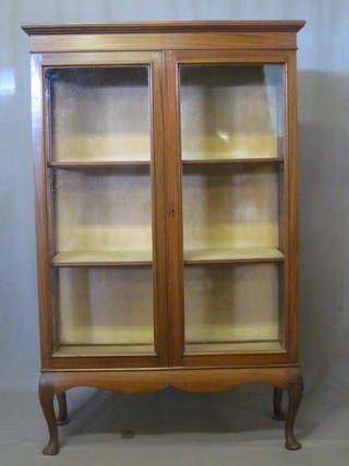 A Victorian walnut display cabinet with moulded cornice, fitted shelves enclosed by glazed panelled door, raised on cabriole  supports 36"