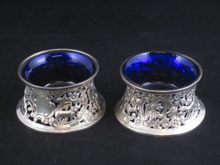 A handsome pair of Edwardian pierced waisted silver salts decorated fox and hounds with blue glass liners, London 1905,  by the Goldsmiths and Silversmiths Company, 5 ozs   ILLUSTRATED