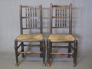 A pair of 18th Century elm bar and spindle back chairs with  woven rush seats, raised on club supports