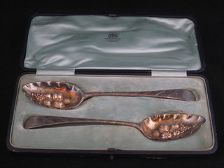 A pair of Georgian embossed and engraved silver berry spoons, London 1813, possibly later embossed, 5 ozs, cased