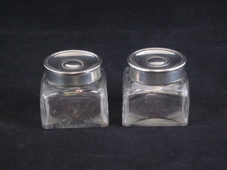 A pair of square cut glass inkwells with silver plated lids, 1 1/2"