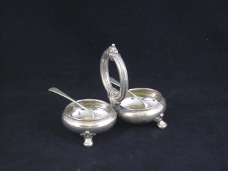A white metal circular twin section salt, the base marked 989 and  2 silver salt spoons