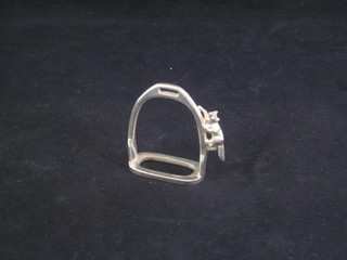 A silver paperweight in the form of a stirrup with fox