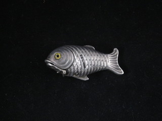 A modern silver vesta case in the form of a fish, the eyes set hard stones