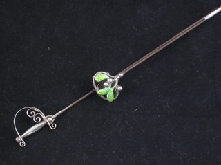 A silver and enamelled hat pin in the form of mistletoe and 1  other in the form of a sword