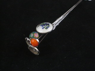 A silver and enamelled hat pin and 4 others