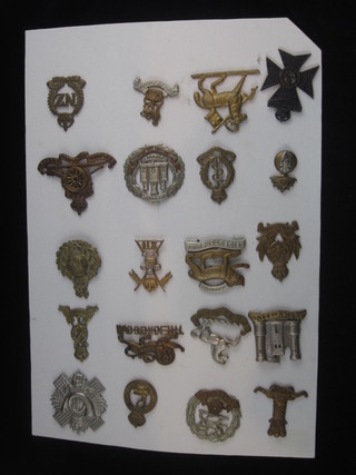 An 11th Husaars cap badge, a 12th Royal Lancers cap badge, a Highland Light Infantry cap badge and 17 other cap badges