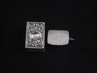 An Edwardian silver pill box, the hinged lid marked Violet, Birmingham 1905 together with an embossed silver match slip 1  1/2"