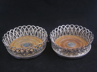 A handsome matched pair of George III circular pierced silver  bottle coasters with cast vinery decoration, London 1788 and  1790  ILLUSTRATED