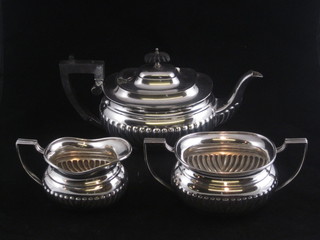A silver plated 3 piece tea service of oval form with demi-reeded decoration comprising teapot, twin handled sugar bowl and cream  jug