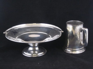 A circular silver pedestal cake basket with swing handle and a silver plated tankard