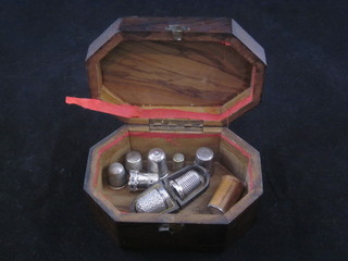An olive wood lozenge shaped trinket box containing 9 various thimbles