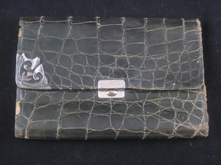 A green snake skin wallet with silver mounts