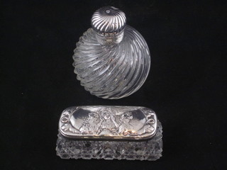 An Edwardian rectangular cut glass dressing table jar with  embossed silver lid decorated young girls, Birmingham 1906 and  a circular glass scent bottle with plated mount