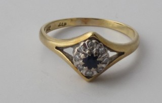 A yellow gold dress ring set a blue stone surrounded by diamonds
