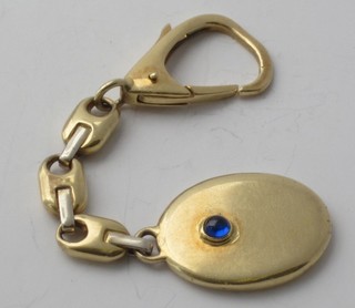 A gold key fob set a cabouchon cut sapphire