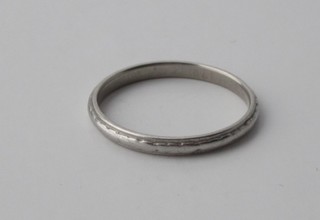 An 18ct white gold or platinum wedding band