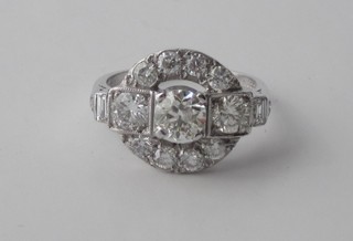 An 18ct white gold dress ring set 3 large circular cut diamonds surrounded by numerous diamonds,