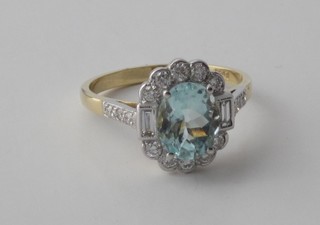A lady's 18ct yellow gold dress ring set an oval cut aquamarine surrounded by numerous diamonds and with 6 diamonds to the  shoulders