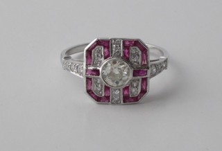 An 18ct white gold dress ring set a large circular cut diamond supported by rubies and diamonds