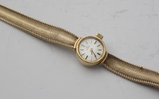 A lady's Omega wristwatch contained in a 9ct gold case and on an integral bracelet