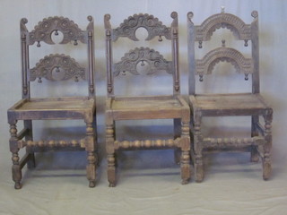 A matched set of 3 19th Century carved oak ladderback hall  chairs with solid seats, raised on turned and block supports