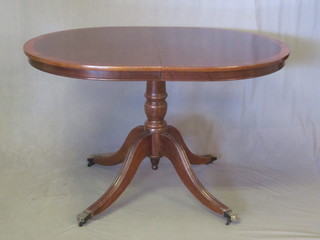 A Georgian style oval mahogany pedestal dining table with  concealed extra leaf, 48"
