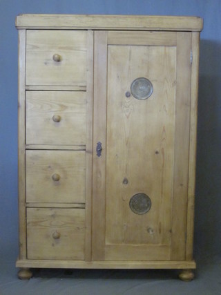 A Continental pine combination cabinet, the interior fitted shelves enclosed by a grilled door and flanked by 4 long drawers with  tore handles, raised on bun feet, 38"