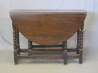 An 18th/19th Century oak drop flap gateleg tea table, raised on  bobbin turned supports 40"