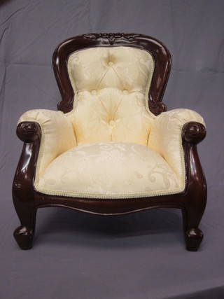A childs Victorian style mahogany framed armchair upholstered  in yellow material, raised on cabriole supports