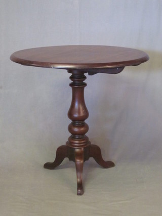 A Victorian circular snap top mahogany tea table, raised on a turned and tripod base 29"
