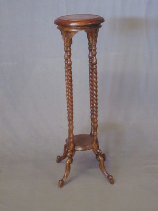A Victorian style circular mahogany 2 tier jardiniere stand, raised on spiral turned supports 12"