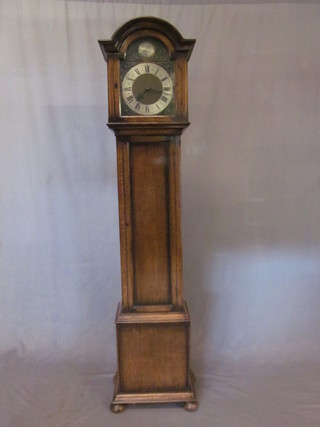A 1930's 8 day striking longcase clock with 10" arched brass dial  and silvered chapter ring, contained in an oak case 75"