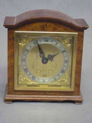 An Elliott bracket clock with square dial having a silvered  chapter ring with Roman numerals contained in an arch shaped  walnut case, 5"  ILLUSTRATED