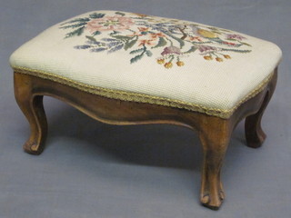 A Victorian bleached walnut stool of serpentine outline with Berlin woolwork seat, raised on cabriole supports 14"