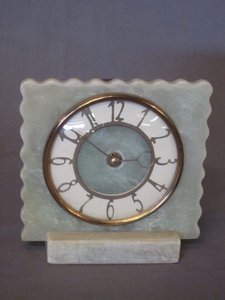 A mantel clock contained in a green onyx case with gilt Arabic numerals