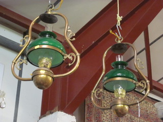 A pair of circular reproduction brass hanging oil lamps with green glass shades
