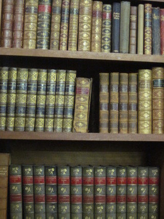 A quantity of various leather bound books, 5 shelves