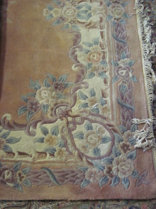 A peach and floral patterned Chinese carpet 120" x 86"