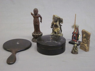 An ebonised hand mirror, a cylindrical box and cover and various Eastern figures of deities