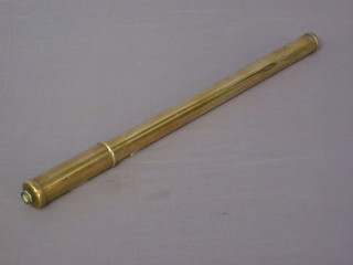 A vintage brass bicycle pump complete with valve
